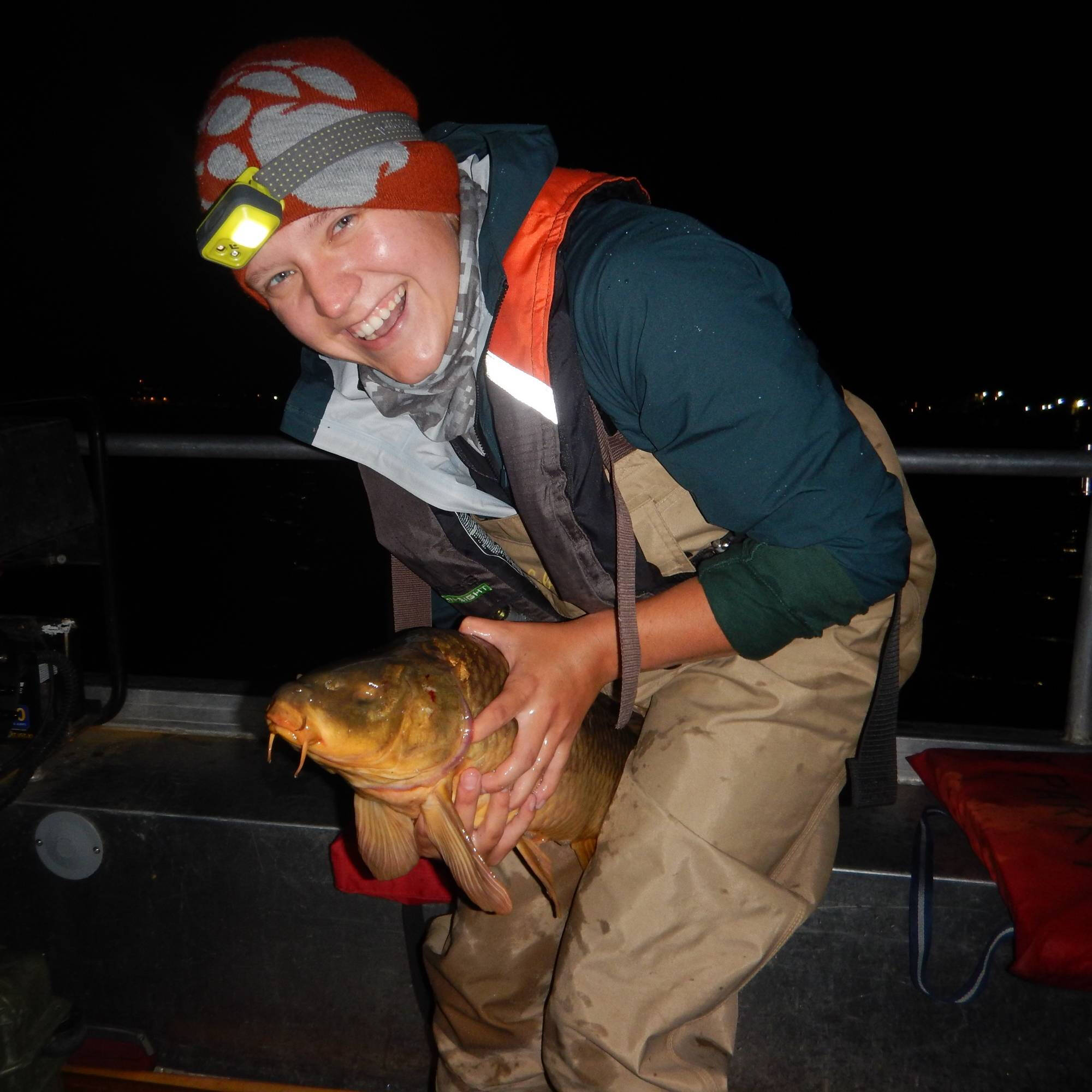 Rachel Pietscher poses with a fish during nighttime electrofishing.